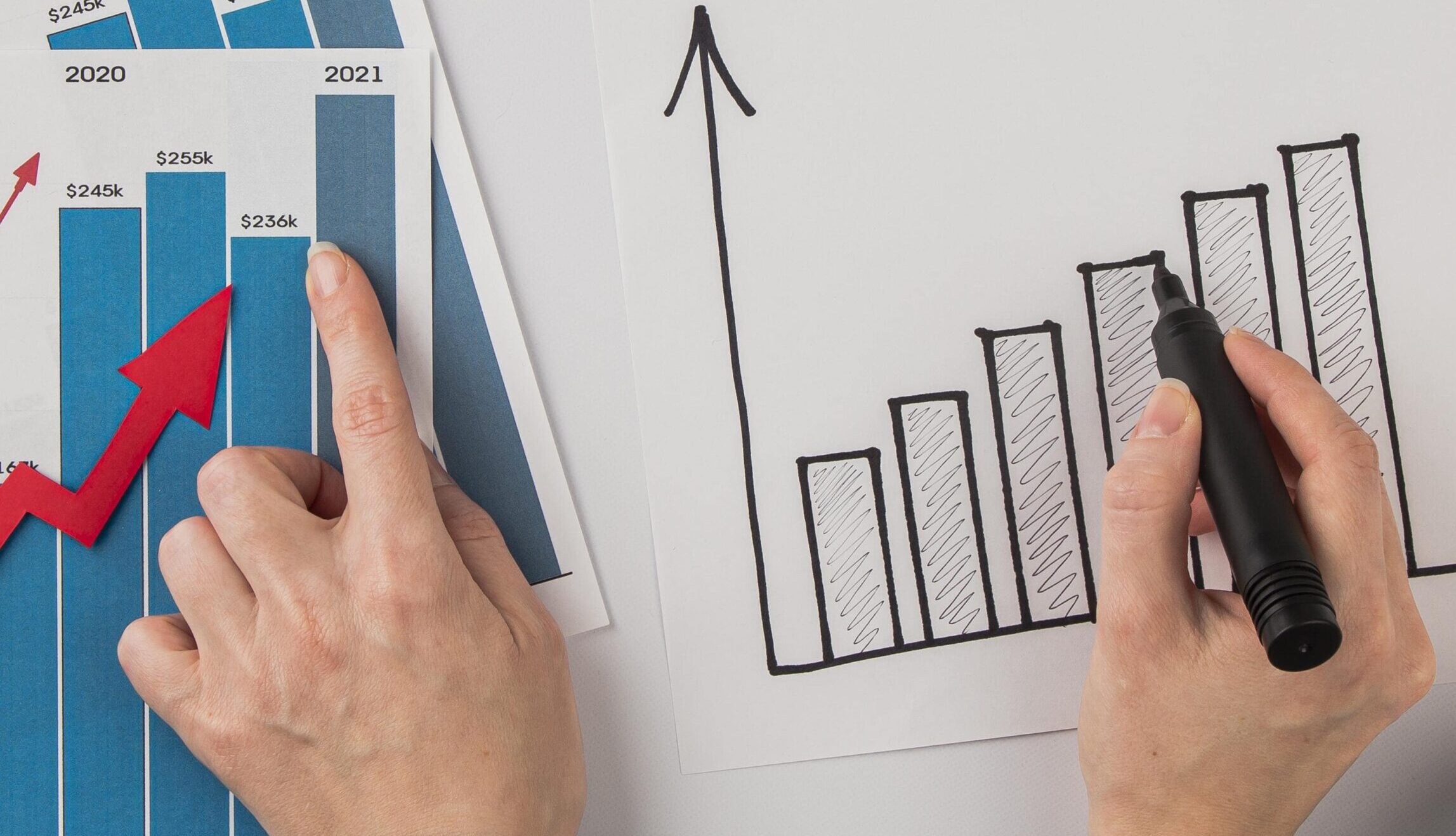 top-view-office-desk-with-growth-chart-hands-min